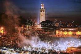 Image du Maroc Professionnelle de  Au coucher du soleil et même un peu avant la foule envahi la fameuse Place Jemaa El Fana qui se métamorphose en un gigantesque restaurant en plein air grâce aux nombreux stands et gargotes qui s'y installent sur ce lieu mythique au centre de la médina de Marrakech. Au fond le minaret de la Koutoubia, Samedi 26 Février 2005. (Photo / Abdeljalil Bounhar)

 